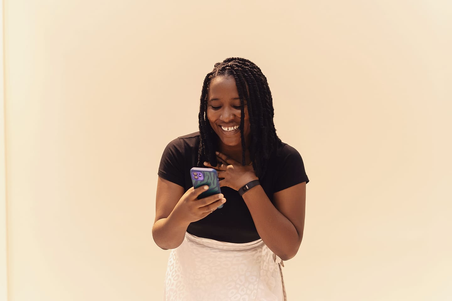 Étudiante souriante qui consulte son téléphone